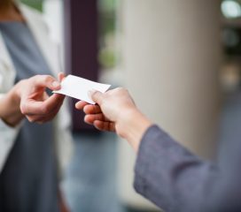 Close-up of business executives exchanging business card at conference centre