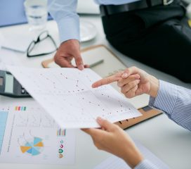 Hands of financial managers pointing at document